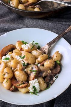 a white plate topped with pasta and mushrooms