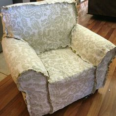 a chair that is sitting on the floor in front of a couch with torn up fabric