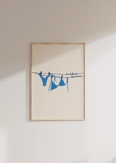 two blue clothes hanging on a line against a white wall