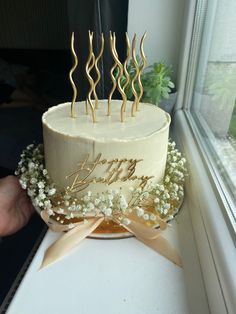 a birthday cake with candles and flowers on it