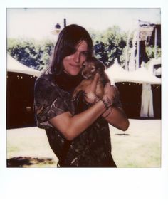 a woman holding a small dog in her arms