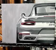 a painting of a porsche car is on display