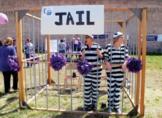 two people dressed in jail clothes standing next to each other with purple pom poms