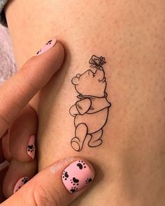 a woman's stomach with a winnie the pooh tattoo on her left side