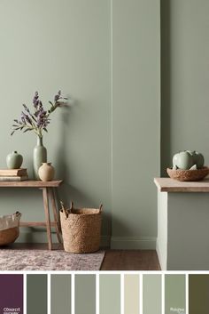 a room with green walls and white trim, including two vases filled with flowers