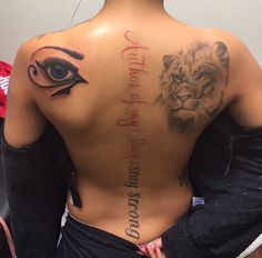 the back of a woman's body with an eye and lion tattoo on it