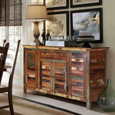 a dining room table and chairs with pictures on the wall