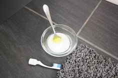 a glass bowl with yogurt and a toothbrush on the floor