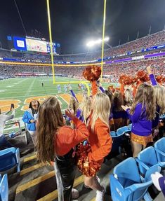 cheerleaders in orange and purple at a football game