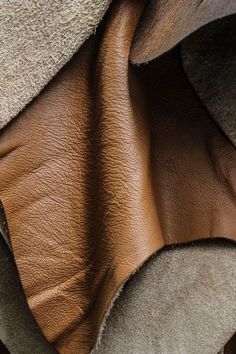 an up close shot of some brown and tan colored leather material, with the top part showing