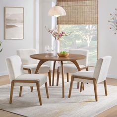 a dining room table with chairs and a vase