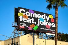 a billboard with the words comedy, teat, jokes on it in front of a palm tree