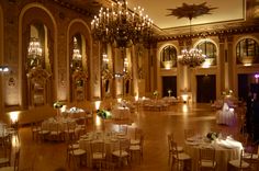 an elegant ballroom with chandeliers and tables