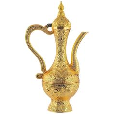 an ornately decorated gold teapot on a white background