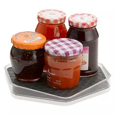 four jars of jam sitting on top of a plastic tray