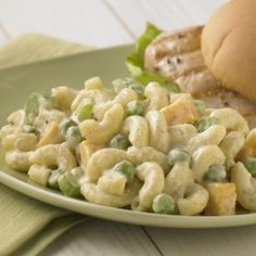 a sandwich and macaroni salad are on a plate next to a green napkin