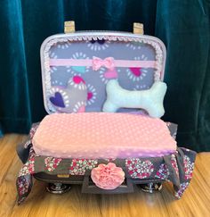 an open suitcase sitting on top of a wooden table next to a stuffed dog toy