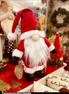 a santa clause figurine sitting on top of a red table next to other christmas decorations