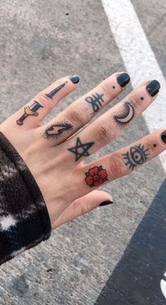 a woman's hand with tattoos on it and two fingers in front of her