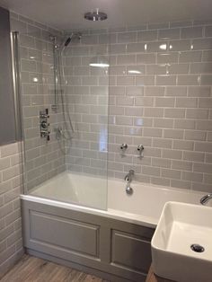 a bath tub sitting next to a white sink under a faucet in a bathroom