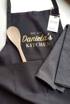 a kitchen apron with a wooden spoon next to it