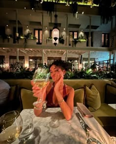 a woman sitting at a table with a glass of wine