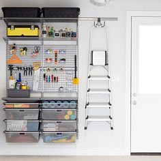 an organized garage with shelves, bins and tools on the wall next to a white door