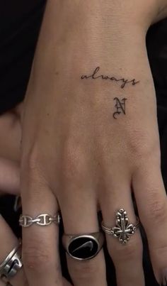 a woman's hand with several rings on it and the word always in cursive writing