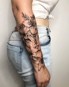 a woman's arm with flowers and a giraffe tattoo on her left arm