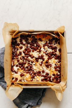 a square casserole dish filled with beans and cheese on top of a cloth