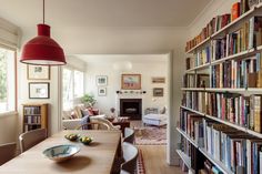 a dining room table with chairs and bookshelves