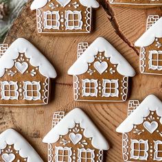 gingerbread cookies decorated with white icing on a wooden table next to pine cones