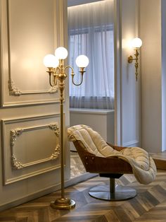 a chair sitting on top of a hard wood floor next to a tall light pole