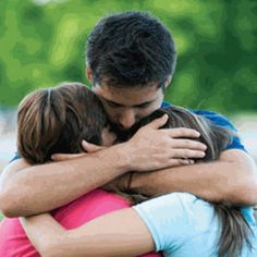 two people are hugging each other outside