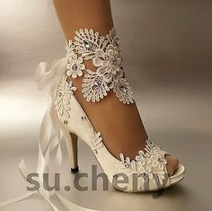 a woman's white high heeled shoe with lace and flowers on the side