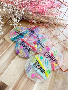 four personalized flip flops sitting on a wooden floor next to flowers and a wire basket