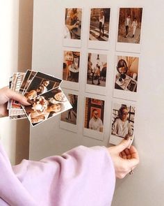 a person holding up photos in front of a wall