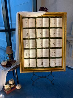 a table that has some books on it with candles in front of it and a lamp next to it