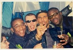 a group of men standing next to each other posing for the camera with drinks in their hands