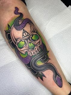 a man with a skull and snake tattoo on his leg