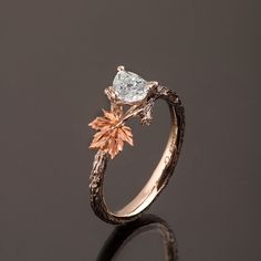 "A hand made twig and leaf ring set with a pear shaped diamond. The ring displays a beautiful twig pattern along with a maple leaf that creates a pleasantly asymmetrical result. A delicate, handmade engagement ring made in two gold colors and set with a natural white diamond of high quality. The grooves in the band are plated with black rhodium which emphasizes the texture. if you prefer not to apply the black rhodium that is fine. I can also use white, rose or yellow gold for the band and the l Twig Engagement Ring Vintage, Maple Leaf Engagement Ring, Laurel Leaf Engagement Ring, Leaf Engagement Ring Simple, Twig And Leaf Engagement Ring, Autumn Engagement Ring, Leaf Wedding Ring Pair, Engagement Ring Twig Band, Engagement Ring Leaves Vines