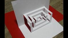 an open white box sitting on top of a red and white floor next to a piece of paper