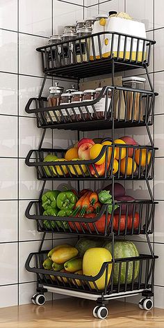 a metal rack filled with fruits and vegetables on top of a wooden table next to a tiled wall