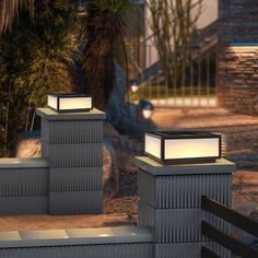 three lights that are sitting on top of some cement blocks in front of a house