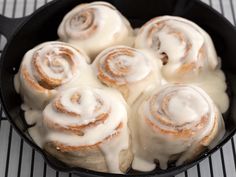 a pan filled with cinnamon rolls covered in icing