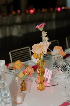 the table is set with pink and orange flowers