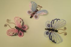 three beaded butterflies sitting on top of a table