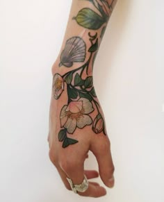 a person's hand with a flower tattoo on it