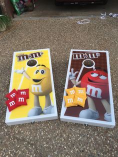 two cornhole game boards with m & m characters on them sitting next to each other