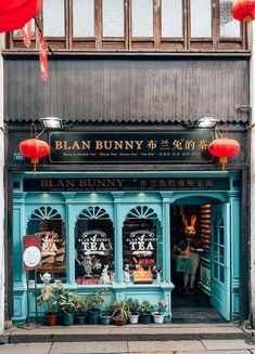 a store front with red lanterns hanging from it's windows and decorations on the outside